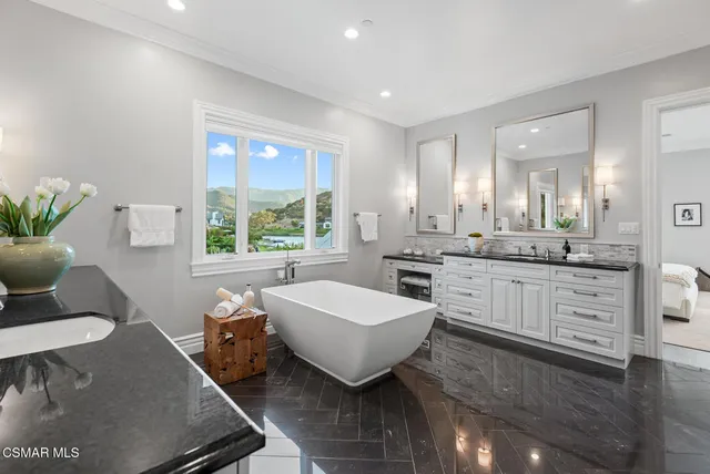 a bathroom with a double vanity sink a mirror and a bathtub