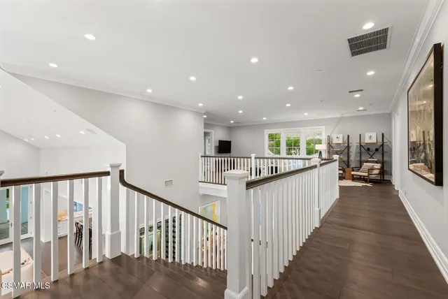 a view of a hallway with wooden floor and windows