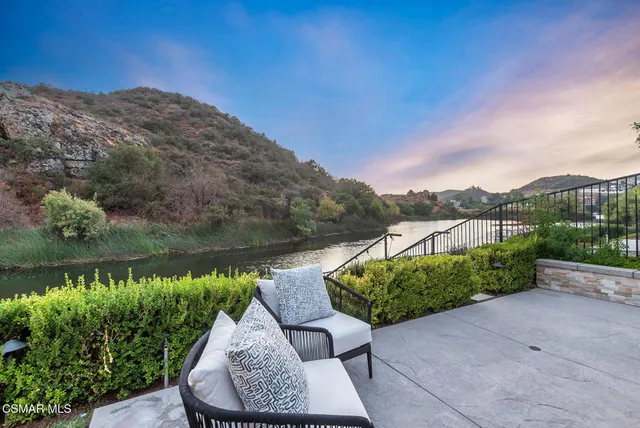 a view of a terrace with yard and mountain view in back