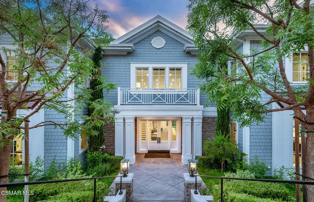 a view of a house with a small yard and a tree