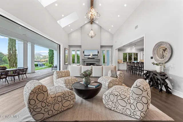a living room with furniture a large window and a chandelier