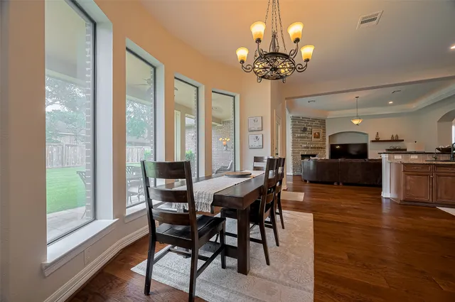 a view of a dining room with furniture a chandelier and wooden floor