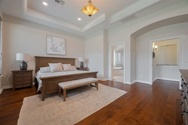 a spacious bedroom with a bed and a lamp