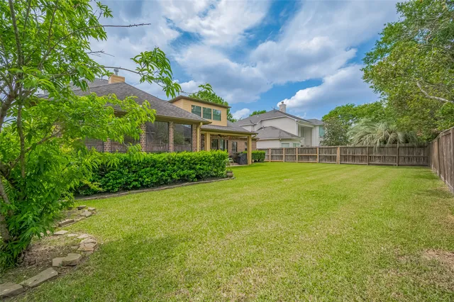 a view of a house with a big yard and a large tree