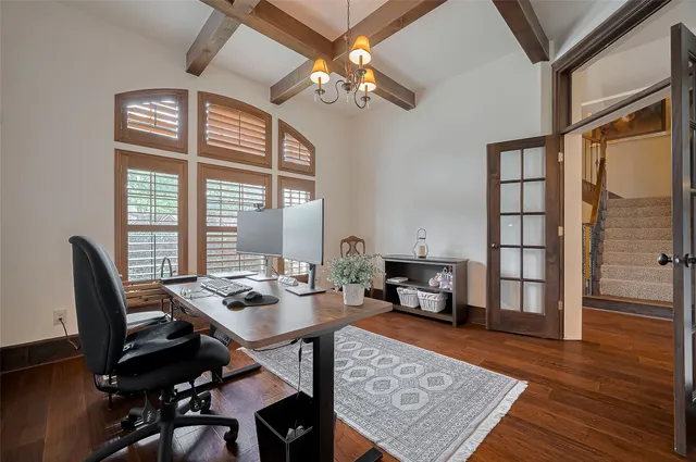 a view of a workspace with furniture and a window