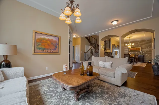 a living room with furniture a chandelier and a rug