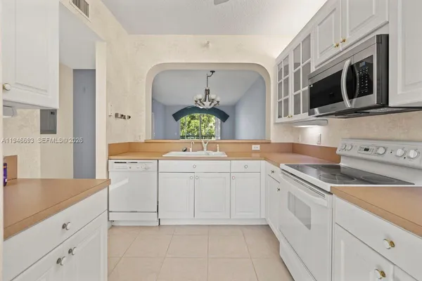 a kitchen with stainless steel appliances white cabinets and a sink