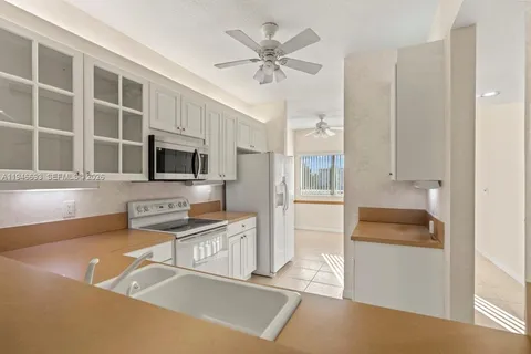 a kitchen with stainless steel appliances a stove a microwave and white cabinets