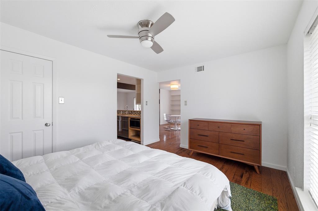 4837 Cedar Springs Road, Unit 311 Dallas, TX 75219 - Photo 14 of 17 Bedroom featuring dark wood-style floors, connected bathroom, and ceiling fan