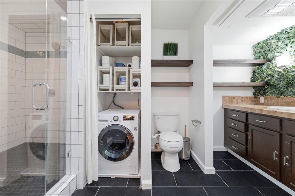 4837 Cedar Springs Road, Unit 311 Dallas, TX 75219 - Photo 16 of 17 Bathroom with washer / dryer, a shower stall, vanity, and dark tile patterned flooring