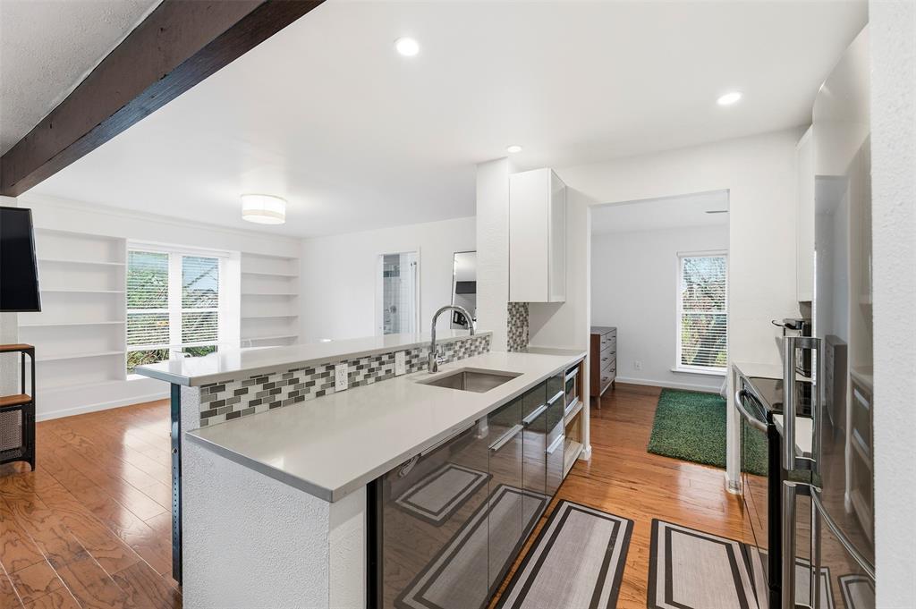 4837 Cedar Springs Road, Unit 311 Dallas, TX 75219 - Photo 7 of 17 Kitchen with white cabinets, modern cabinets, light wood-style flooring, stainless steel appliances, and beamed ceiling