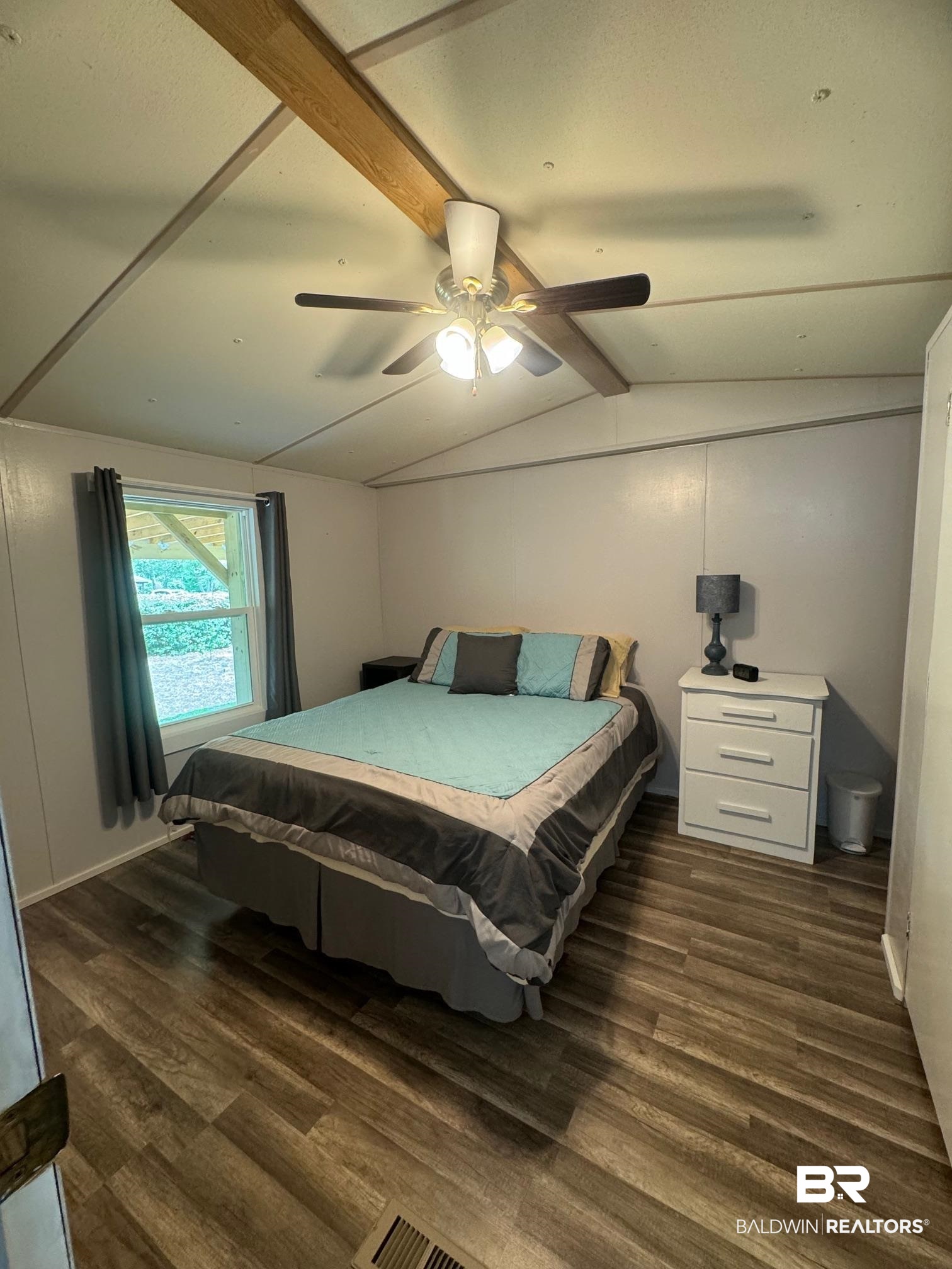 1420 Ridgewood Circle Lillian, AL 36549 - Photo 14 of 41 Bedroom featuring dark wood-type flooring, ceiling fan, and vaulted ceiling with beams