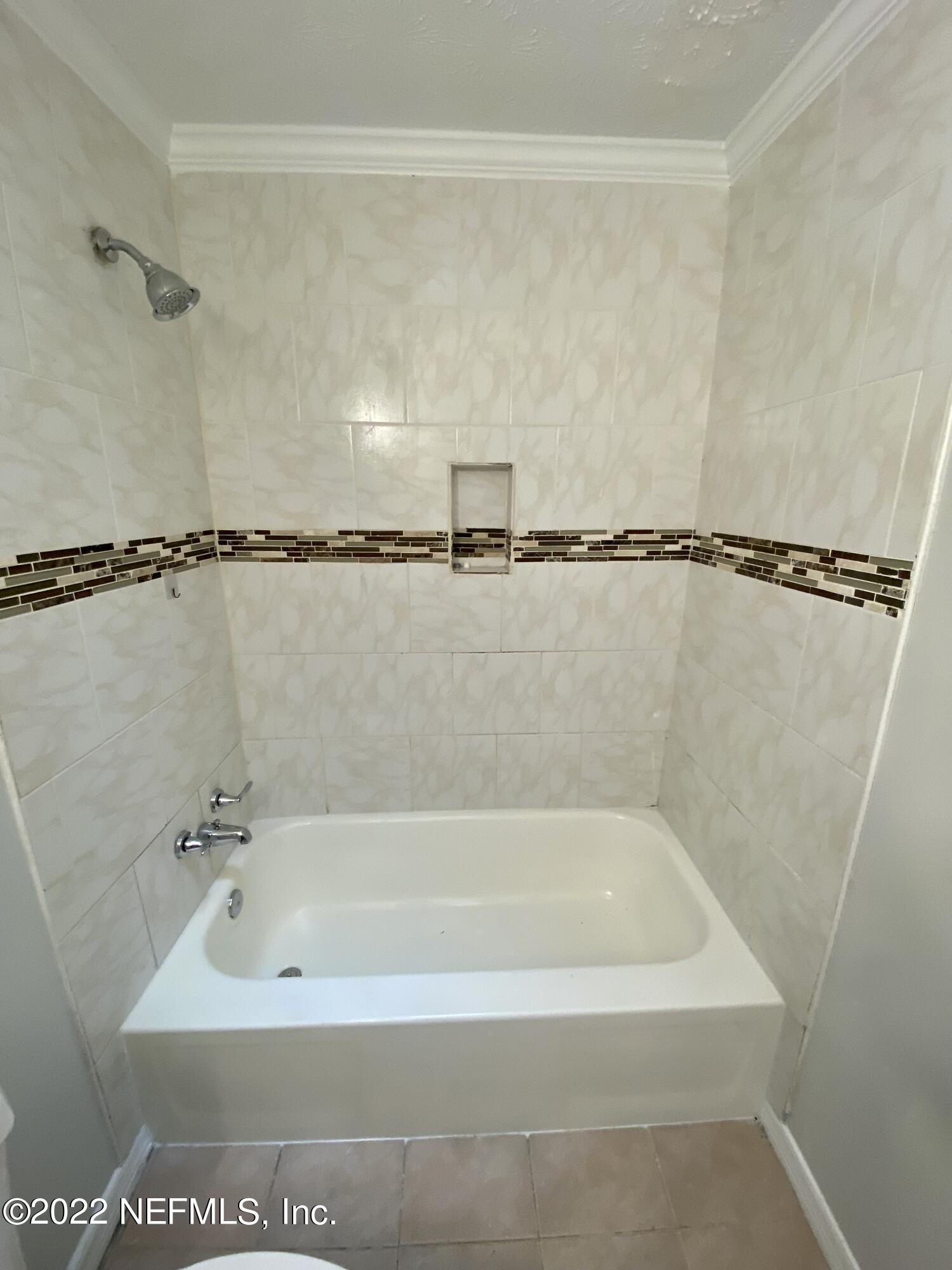 7361 Wheat Road Jacksonville, FL 32244 - Photo 14 of 20 a bathroom with a shower and a bath tub
