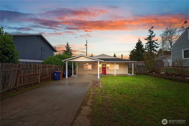 a view of a yard in front of a house with large trees