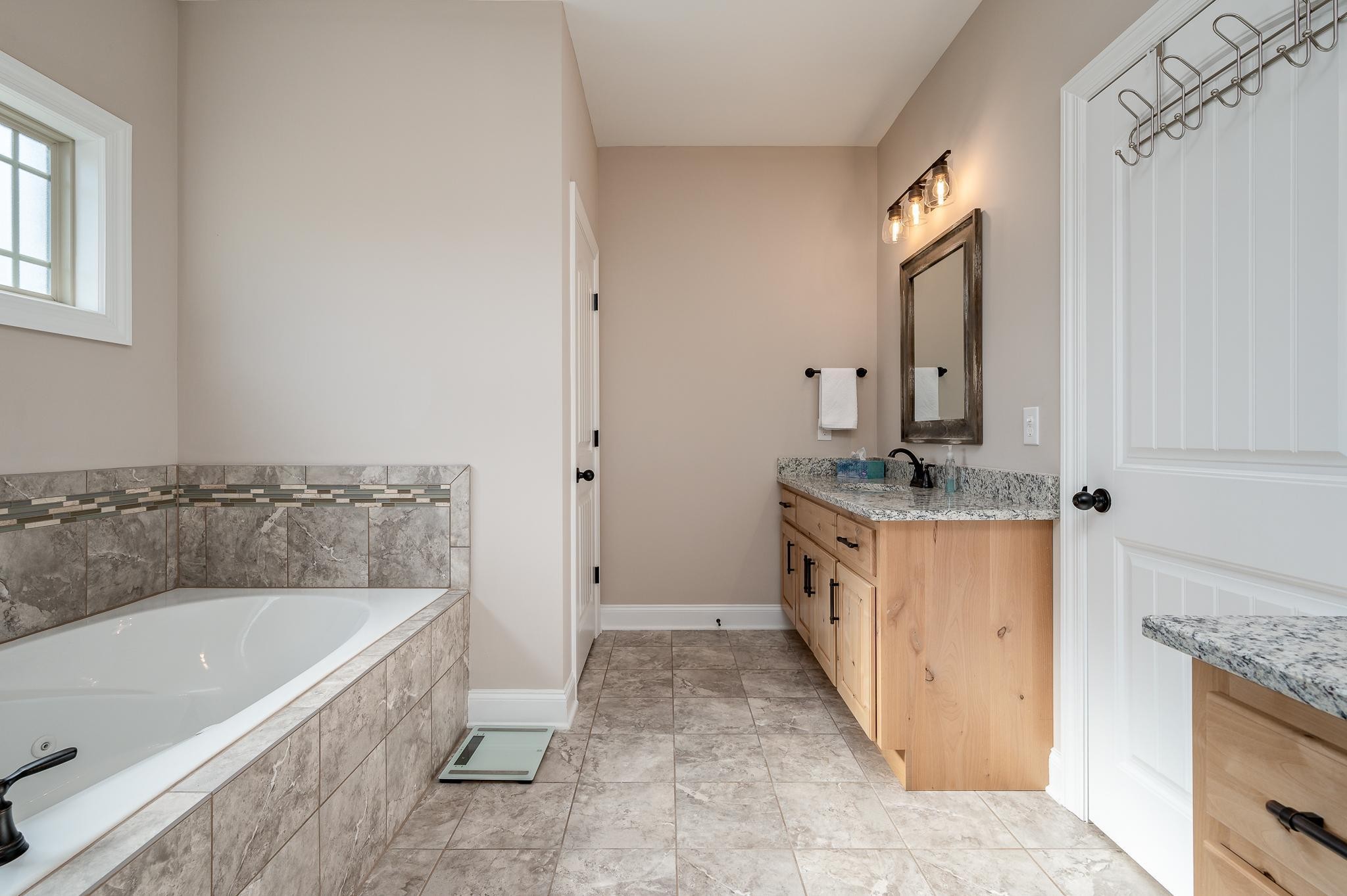 4306 Singleton Drive Murfreesboro, TN 37127 - Photo 12 of 34 a bathroom with a granite countertop tub sink and mirror