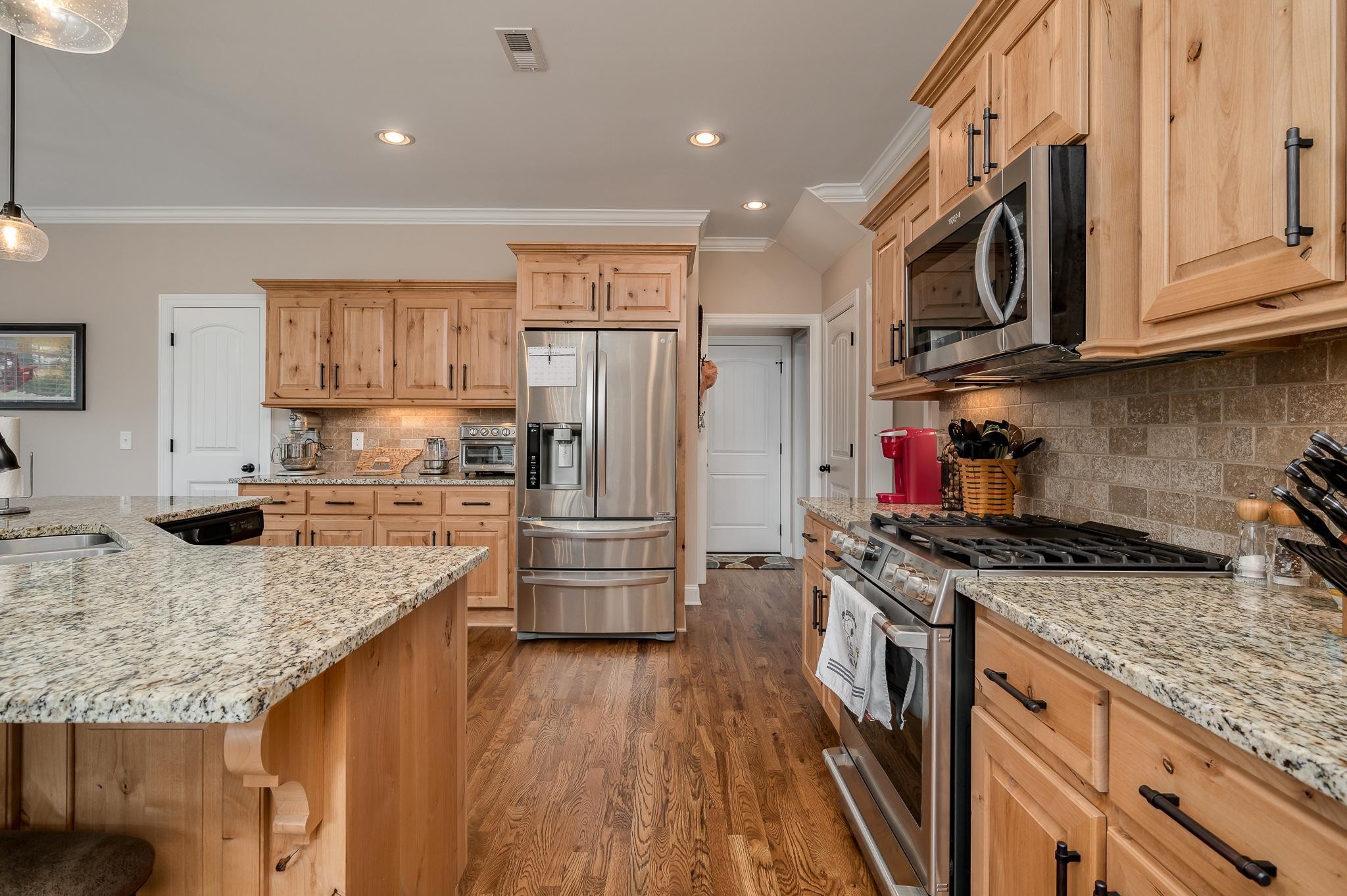4306 Singleton Drive Murfreesboro, TN 37127 - Photo 15 of 34 a kitchen with stainless steel appliances granite countertop a stove top oven a refrigerator a sink and dishwasher with wooden floor