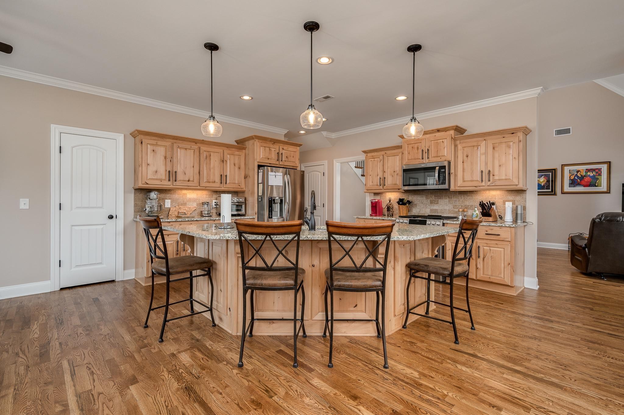 4306 Singleton Drive Murfreesboro, TN 37127 - Photo 18 of 34 a open kitchen with stainless steel appliances granite countertop a dining table chairs stove and white cabinets