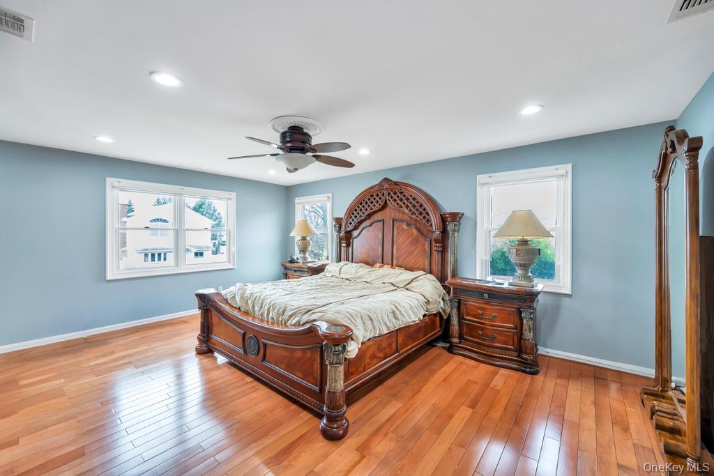 6 Garden Circle Syosset, NY 11791 - Photo 13 of 29 a spacious bedroom with a bed and a large window