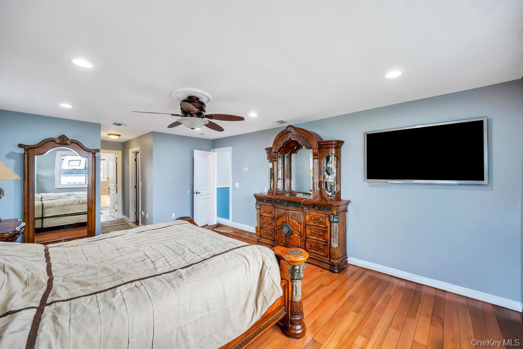 6 Garden Circle Syosset, NY 11791 - Photo 16 of 29 a bedroom with a bed and a flat screen tv