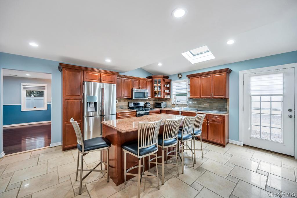 6 Garden Circle Syosset, NY 11791 - Photo 5 of 29 a kitchen with stainless steel appliances kitchen island granite countertop a refrigerator a stove a sink a dining table and chairs
