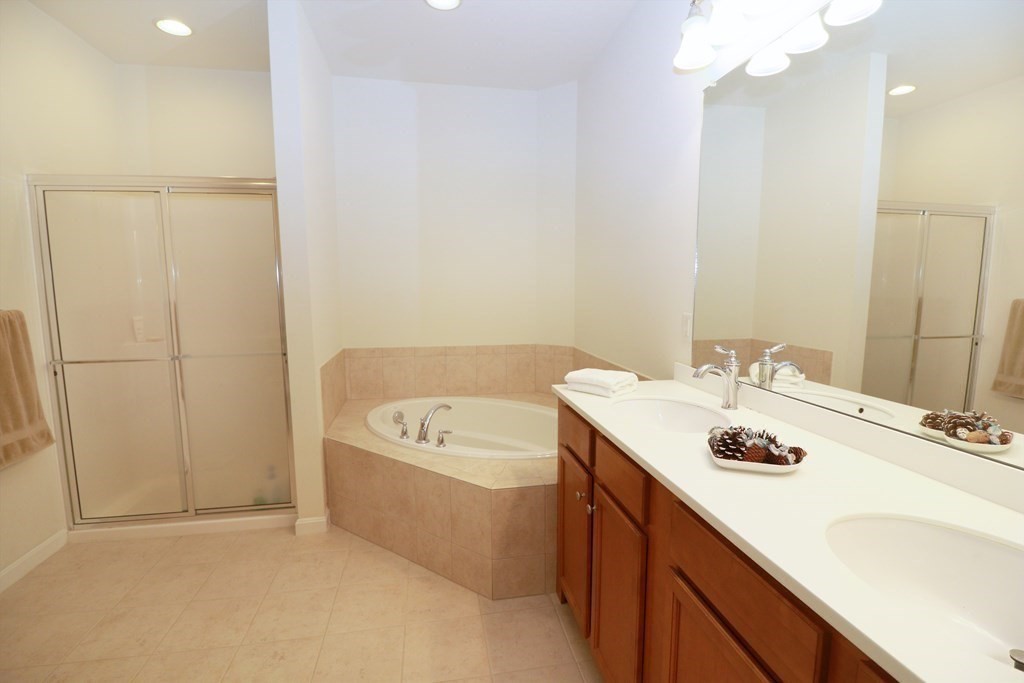 7 Morgan Drive, Unit 104 Natick, MA 01760 - Photo 11 of 26 a bathroom with a tub sink and mirror