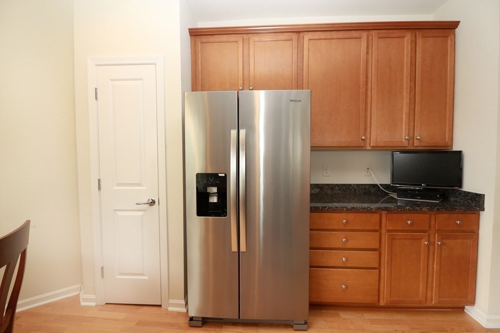 7 Morgan Drive, Unit 104 Natick, MA 01760 - Photo 6 of 26 a kitchen with stainless steel appliances a refrigerator and cabinets