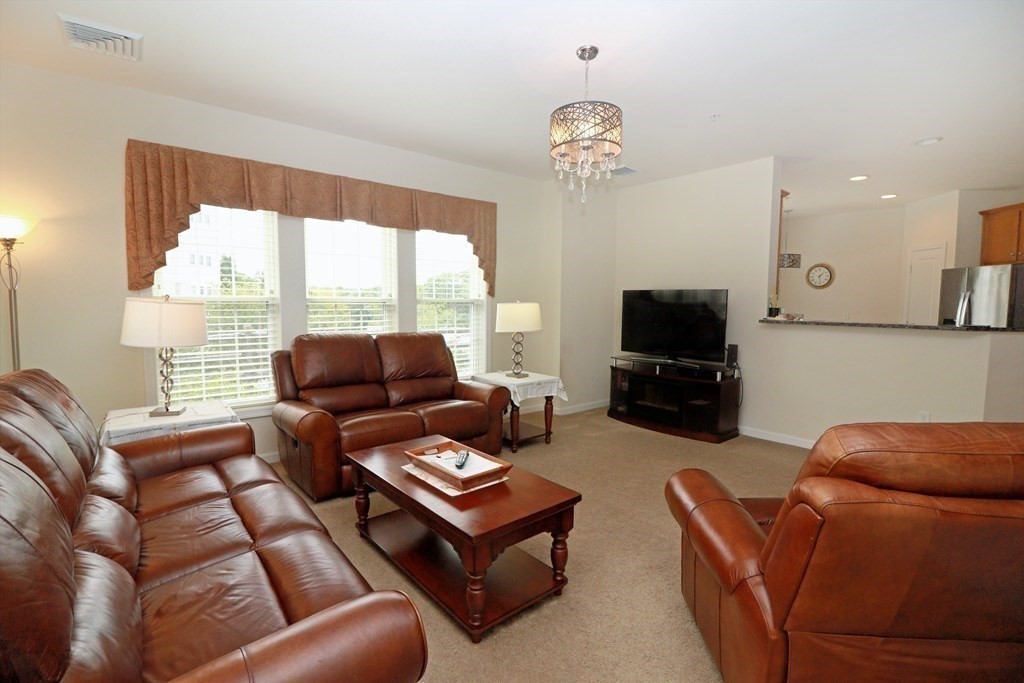 7 Morgan Drive, Unit 104 Natick, MA 01760 - Photo 7 of 26 a living room with furniture and a flat screen tv