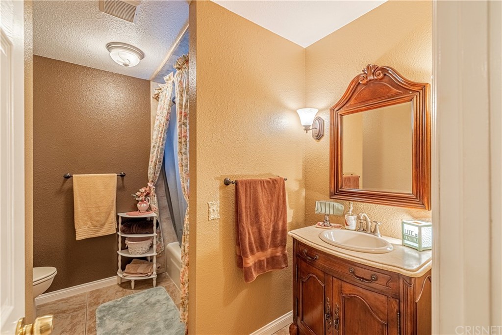 2701 West Ave J4 Lancaster, CA 93536 - Photo 25 of 46 a bathroom with a sink and a mirror