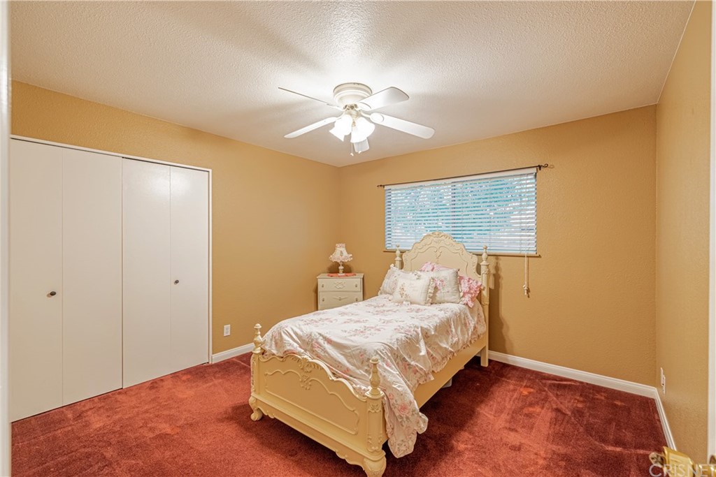 2701 West Ave J4 Lancaster, CA 93536 - Photo 27 of 46 a bedroom with a bed and a chandelier