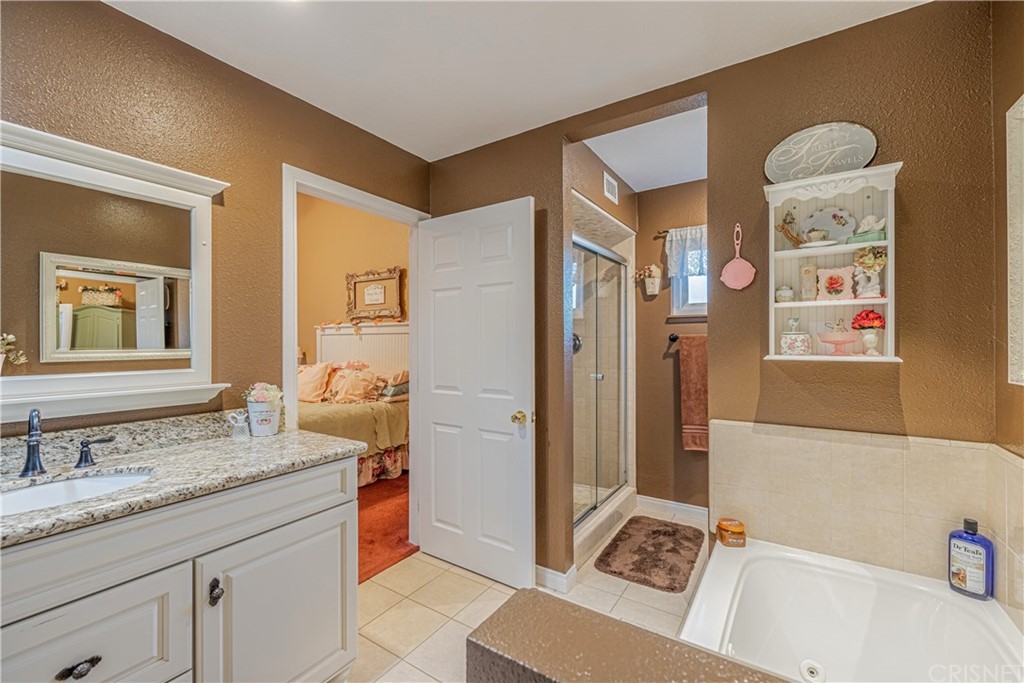 2701 West Ave J4 Lancaster, CA 93536 - Photo 31 of 46 a spacious bathroom with a granite countertop sink and a mirror