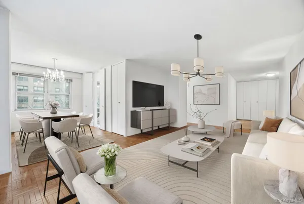 a living room with furniture a flat screen tv and a chandelier