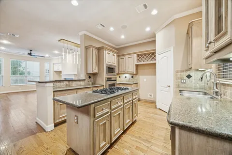 a kitchen with stainless steel appliances granite countertop a sink stove and cabinets
