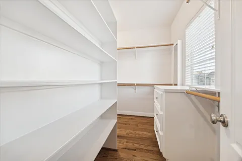 a hallway with white cabinets and wooden floor