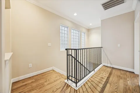 a view of a hallway with wooden floor and a window