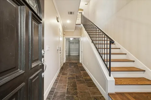 a view of staircase with lots of frames on wall and windows