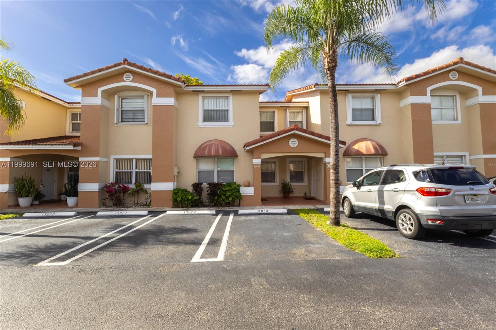 a front view of a house with a garden and parking space