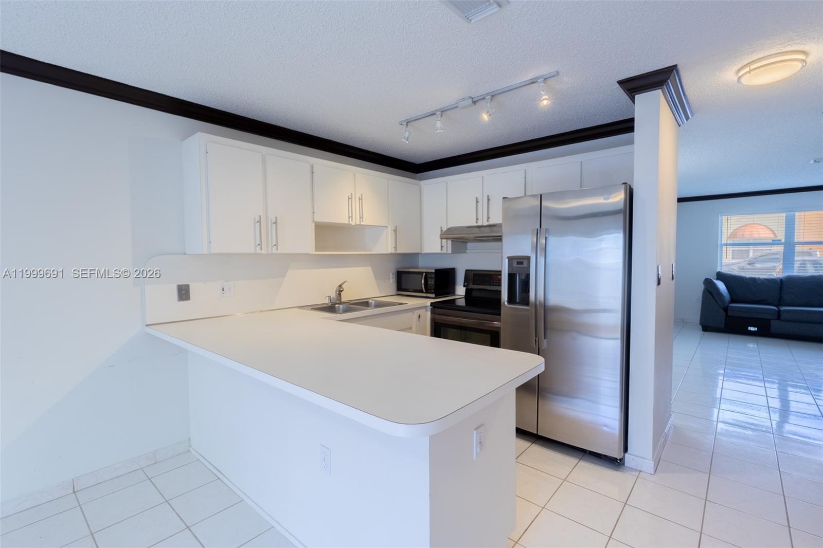 13874 Southwest 64th Street Miami, FL 33183 - Photo 12 of 25 a kitchen with a sink a counter top space cabinets and stainless steel appliances