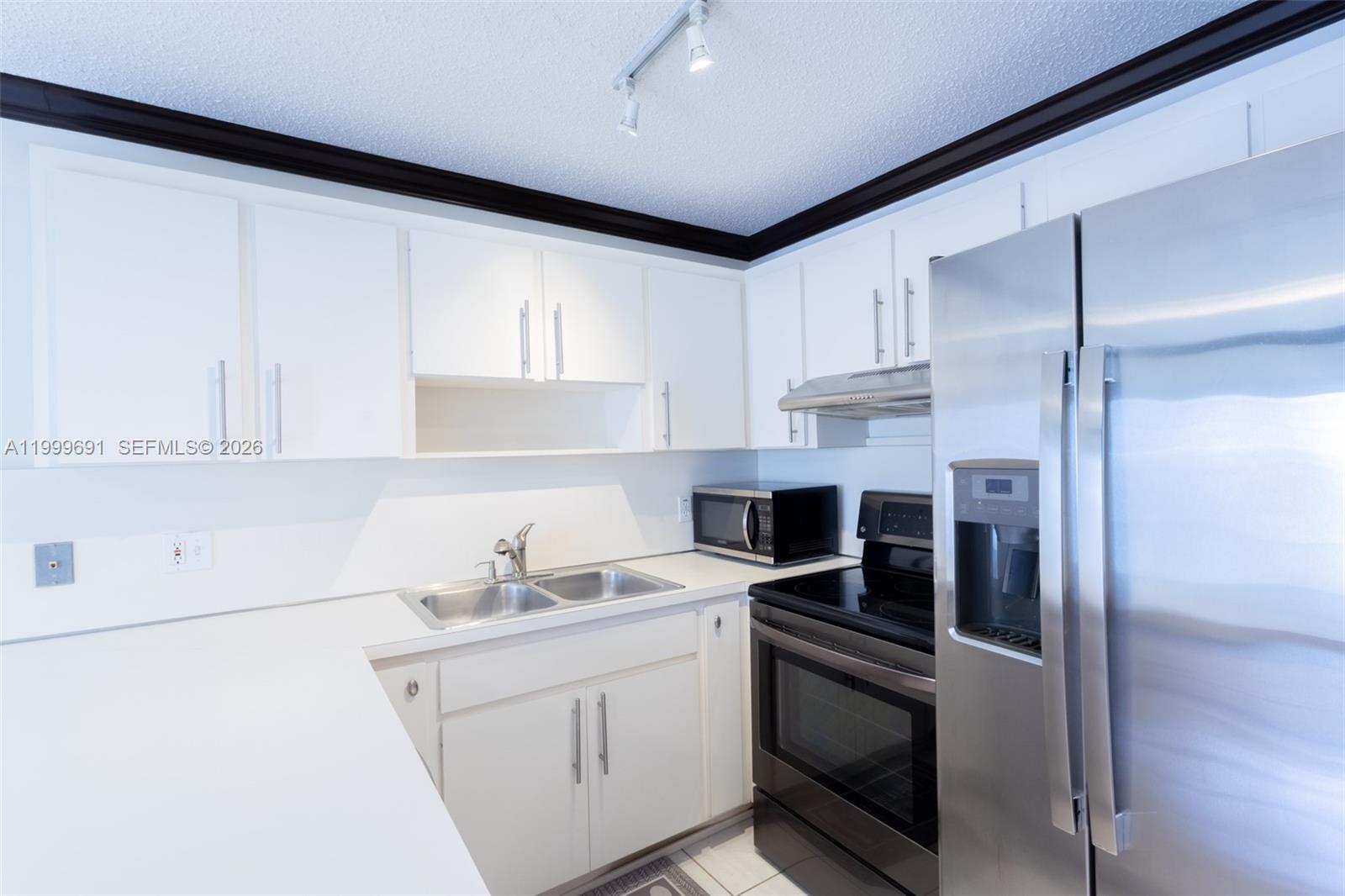 13874 Southwest 64th Street Miami, FL 33183 - Photo 13 of 25 a kitchen with stainless steel appliances white cabinets and a sink
