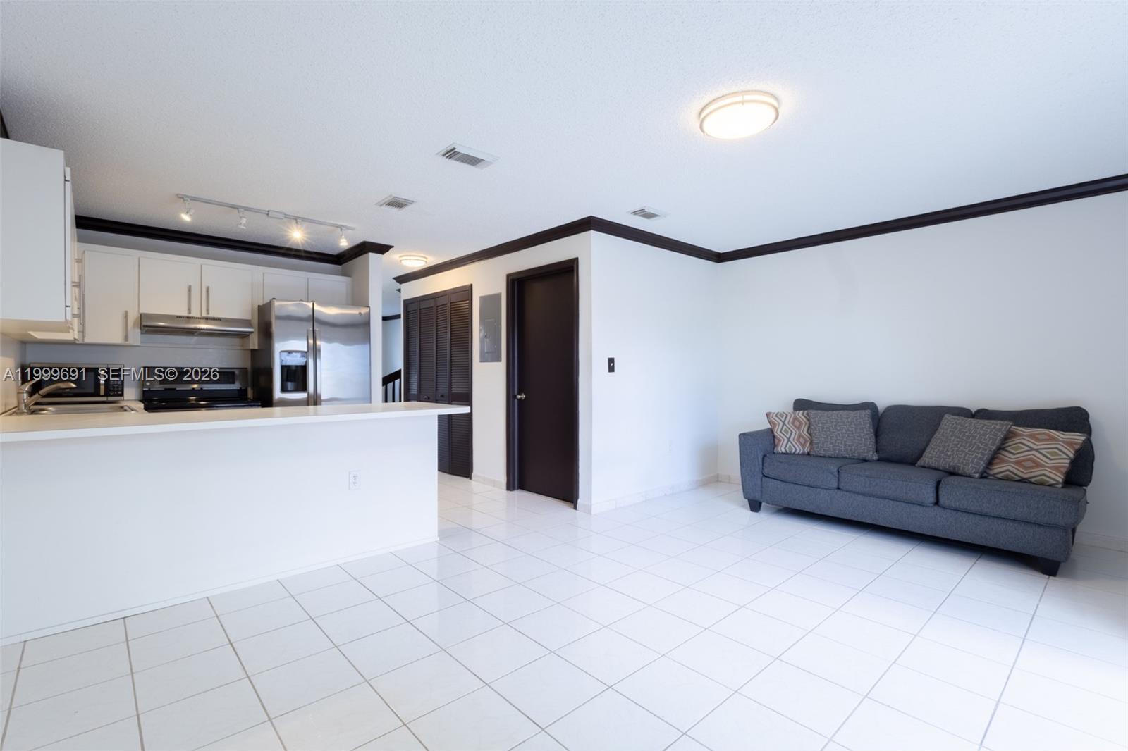 13874 Southwest 64th Street Miami, FL 33183 - Photo 16 of 25 a living room with furniture and a flat screen tv