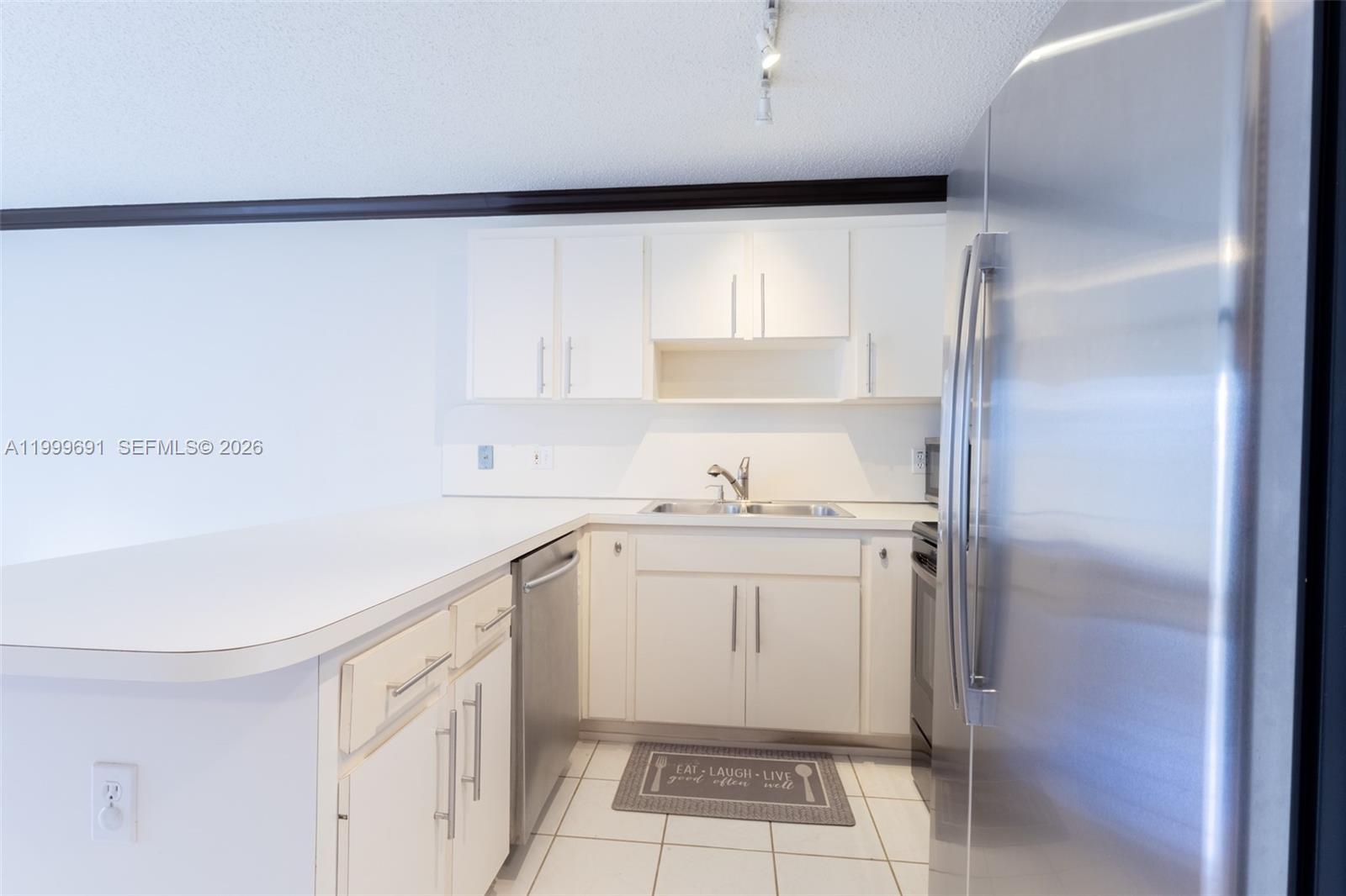 13874 Southwest 64th Street Miami, FL 33183 - Photo 10 of 25 a kitchen with a sink a refrigerator and cabinets
