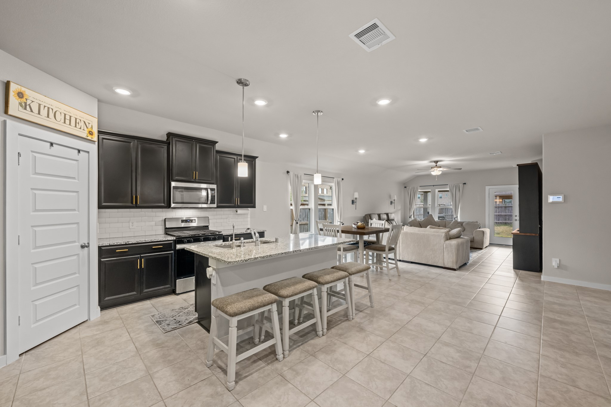 1326 Taft Pt Lane Rosharon, TX 77583 - Photo 7 of 39 a large kitchen with kitchen island a stove a sink a dining table and chairs