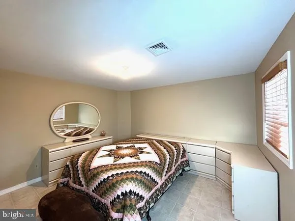 a bedroom with a bed and a large mirror next to a window