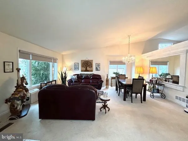a living room with furniture a large window and gym equipment
