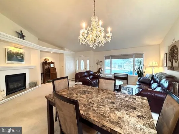 a living room with furniture a fireplace and a chandelier