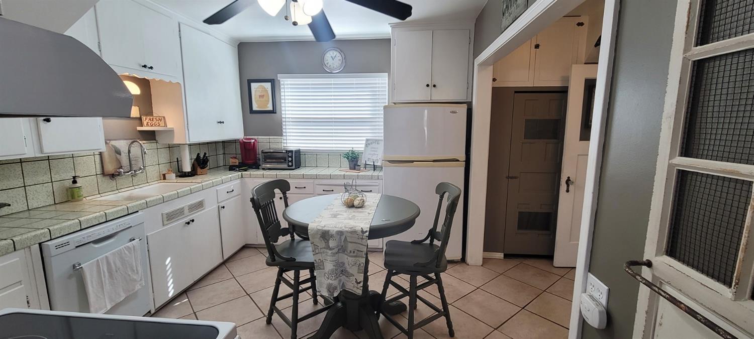 1410 10th Street Reedley, CA 93654 - Photo 23 of 44 a kitchen with granite countertop a sink appliances a counter space and cabinets