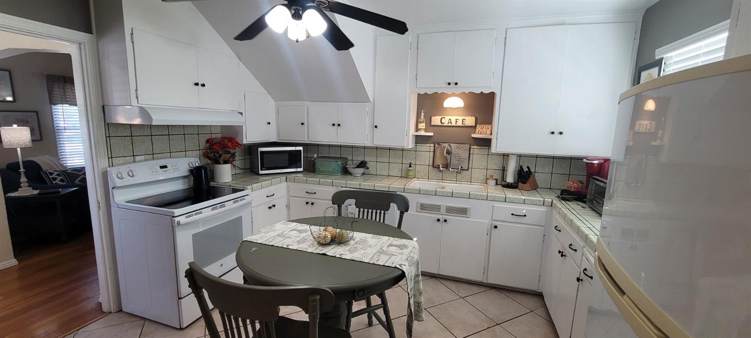 1410 10th Street Reedley, CA 93654 - Photo 24 of 44 a kitchen with a sink refrigerator and cabinets