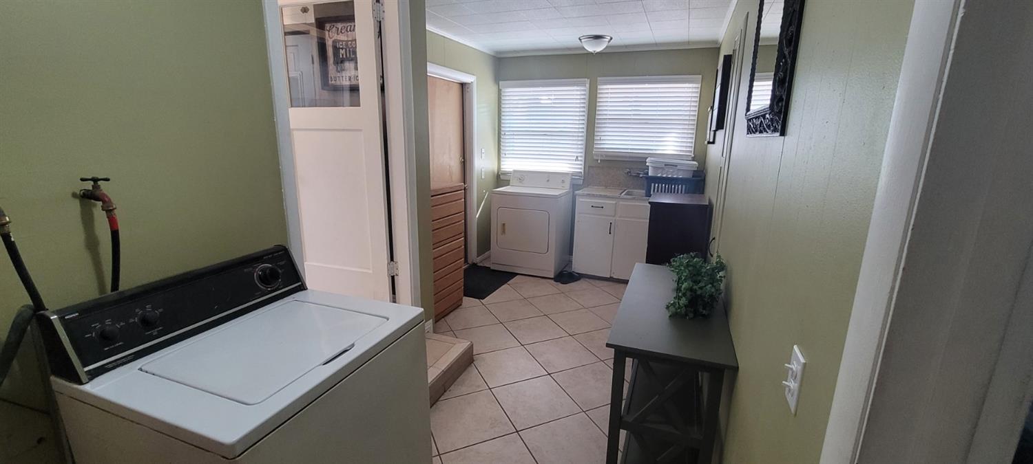 1410 10th Street Reedley, CA 93654 - Photo 26 of 44 a kitchen with a refrigerator and white cabinets