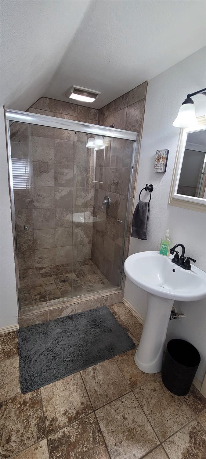 1410 10th Street Reedley, CA 93654 - Photo 28 of 44 a bathroom with a sink and a mirror