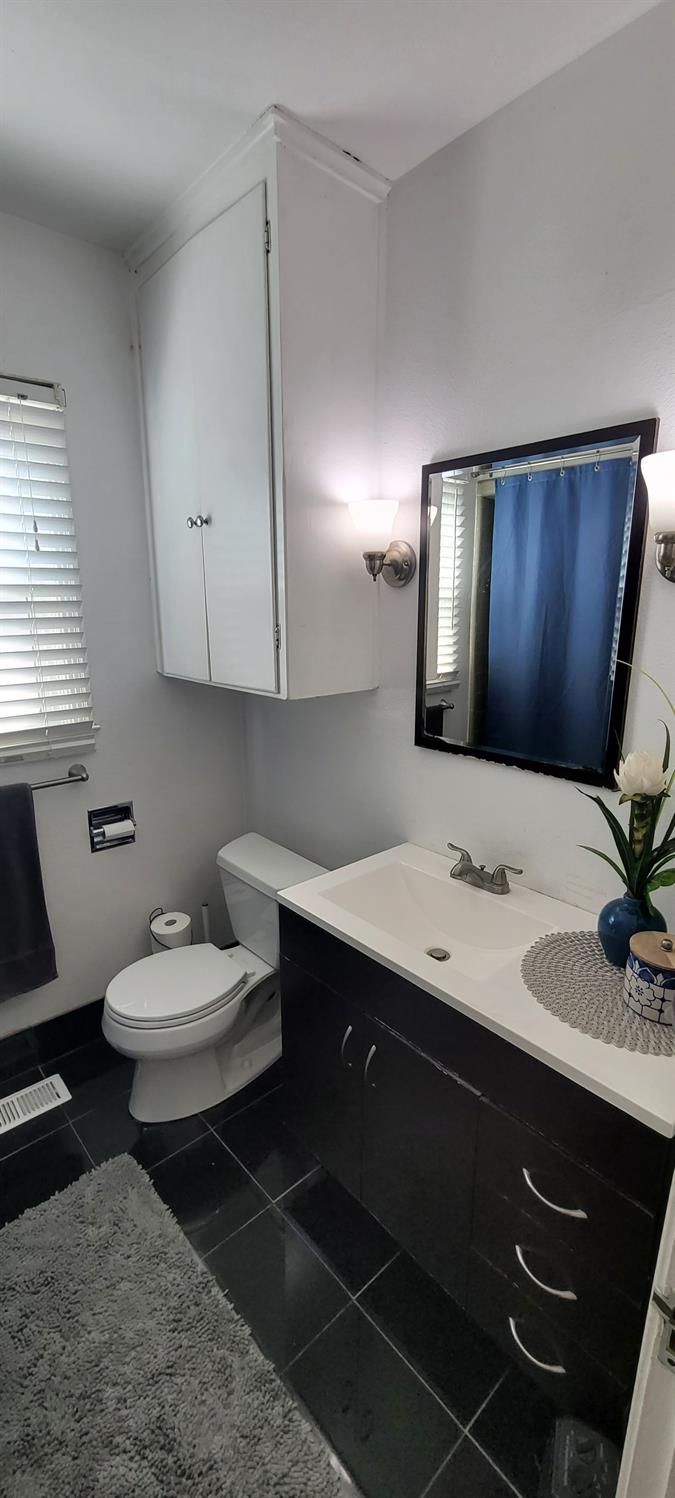 1410 10th Street Reedley, CA 93654 - Photo 29 of 44 a bathroom with a toilet sink and mirror