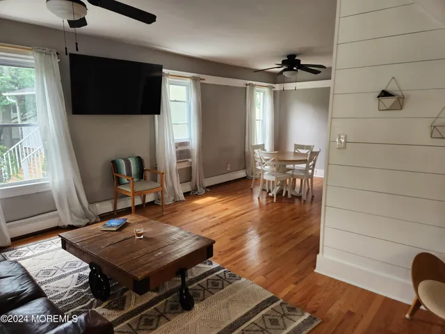 a living room with furniture a flat screen tv and kitchen view